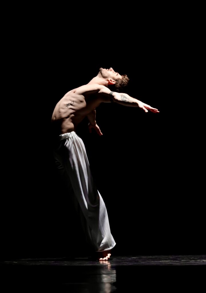 Alberto Tardanico executing an expressive dance pose, photographed by Hans Gerritsen, highlighting his strength, technique, and stage presence.